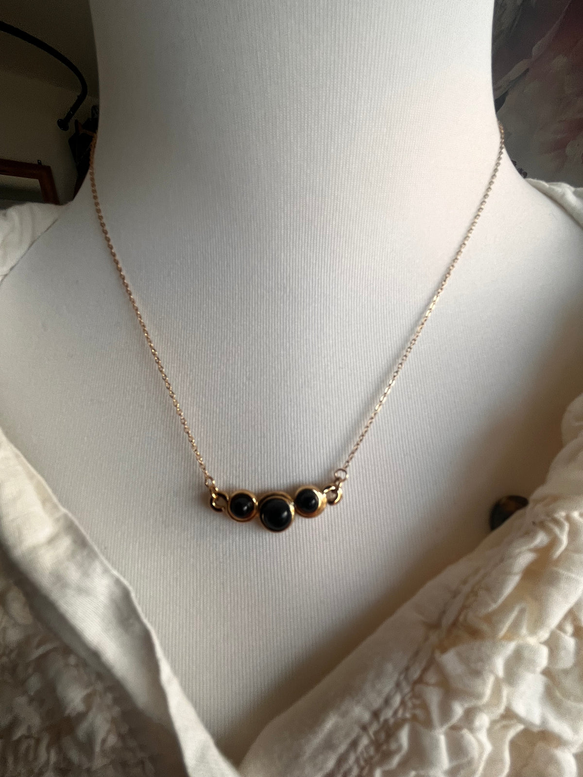 Collier doré, perles noires